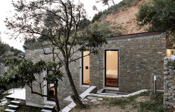 pequeña casa construida en la ladera de la montaña con un diseño de piedra natural