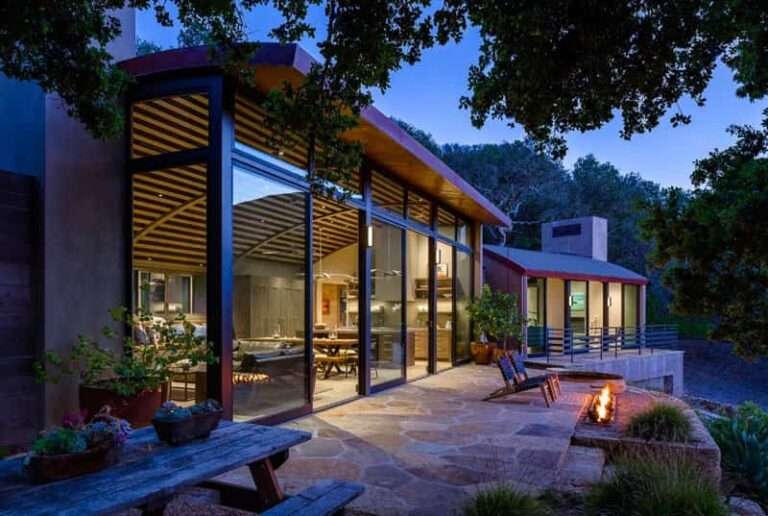 Moderna casa que cuenta con techos de madera curvos
